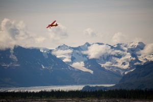 bush plane flying over glacier