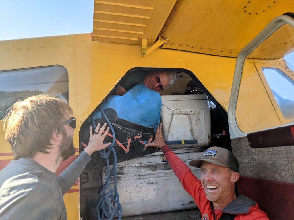 Two guides load up a full bush plane with gear