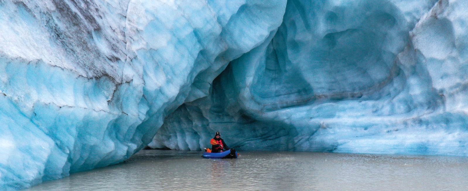 Kayaker emerges from an enormous iceberg