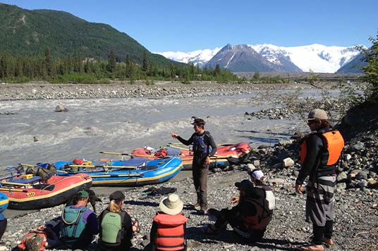 A rafting guide conducts a safety talk with his clients before setting out on the river
