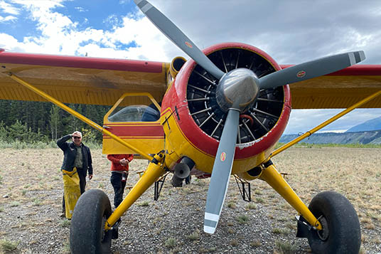A close up shot of the front propeller of a yellow bush plane.
