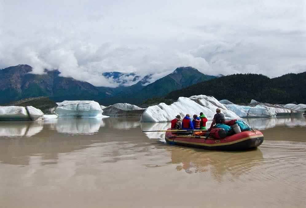 Full raft floating through the silty waters of Nizina Lake