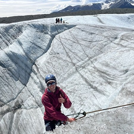 Happy Ice Climber at the top of a glacial wall