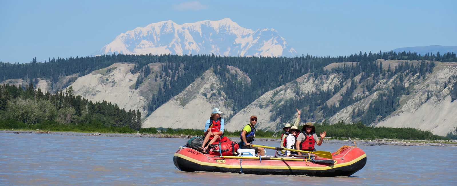 Rafters on the Copper River in Alaska with a large mountain behind them