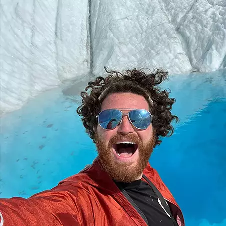 Man smiling while taking selfie on Root Glacier