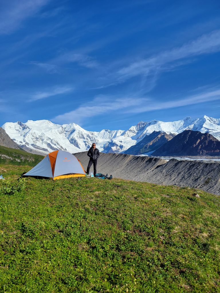Tent and happy camper on tundra with Mt. Blackburn in the background