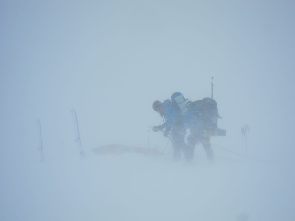 Mountaineers pushing through a blizzard and whiteout