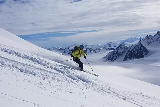A skier shreds downhill in backcountry Alaska