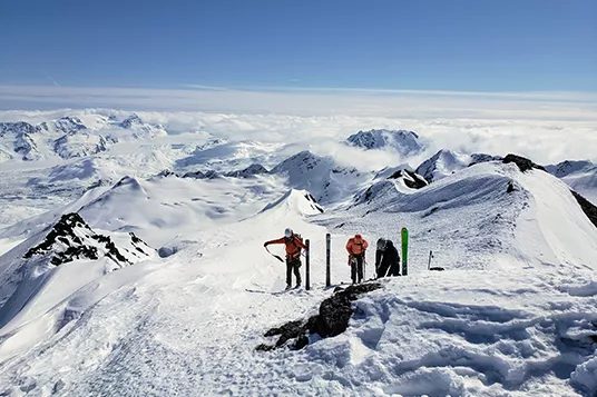 Backcountry skiers transition at the top of a mountain in Alaska
