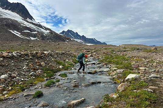 A woman crosses a stream