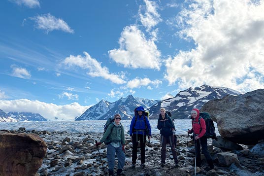 Happy backpackers pose on a glacier in the Wrangells