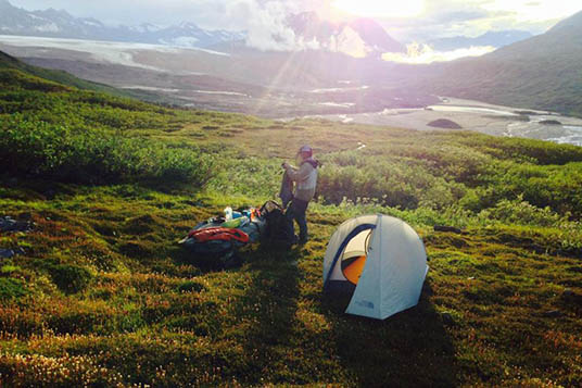 A backpacker setting up camp in the Chugach Mountains