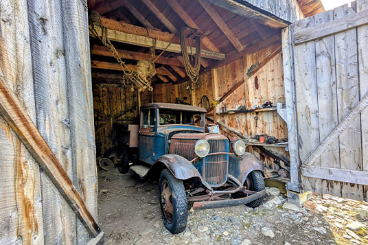 An old Model-T Ford in a wooden garage