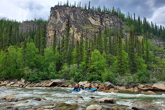A raft navigates rapids on the Charley River