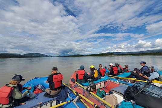 Rafters sitting on three rafts on the Yukon River