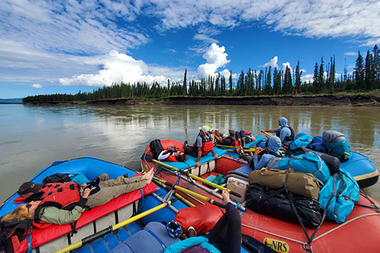 Three rafts tied together with sleeping rafters and a lot of gear