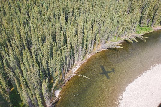 The shadow of a plane seen in the river it's flying above