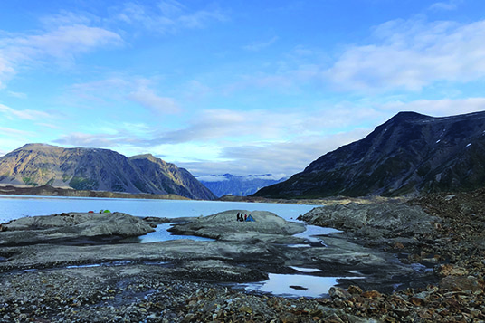 A group of people on a peninsula on a huge lake in the Alaskan backcountry