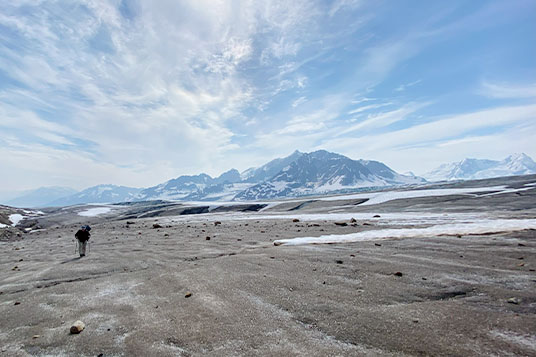 An expansive view of a huge glacier with mountains in the background