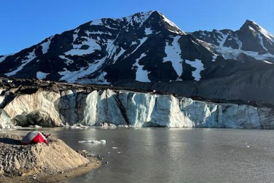A tent at the edge of a glacial lake