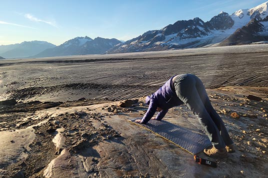 A hiker does yoga on the glacier