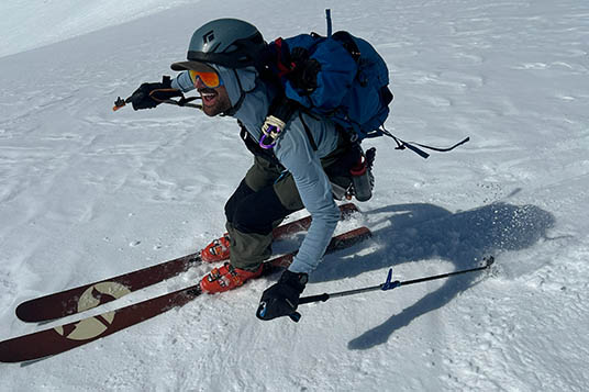 A smiling skier turns in the snow