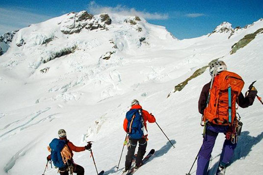A group of backcountry skiers assess their line