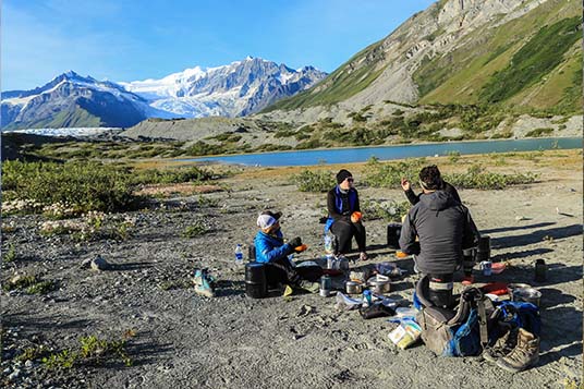 People enjoying food at a backcountry camp