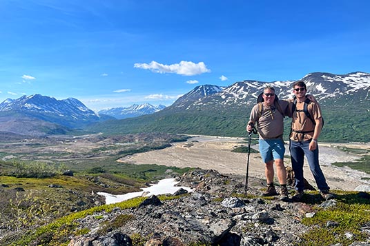 Two hikers pose in front of the Fan Glacier Valley in the Chugach Mountains