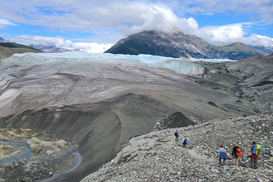 Hikers approaching the Root Glacier on the Root Glacier Trail