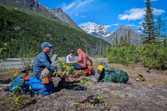 A family of backpackers takes a break on some rocks in Wrangell - St. Elias National Park