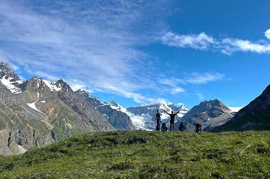Two backpackers take a break from their packs and enjoy the mountain views