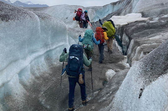 Backpackers move through glacial terrain