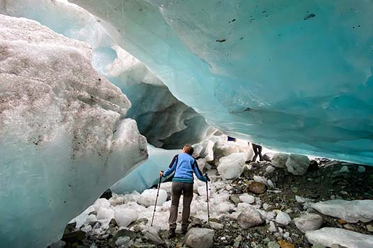 A hiker exploring beached icebergs