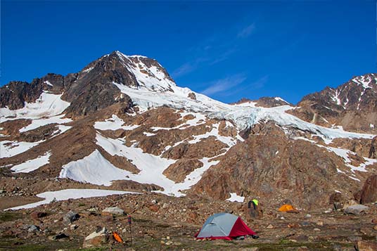 A couple of tents are set up in the backcountry of Wrangell - St. Elias National Park