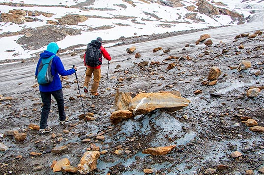 Two backcountry hikers cross a glacier