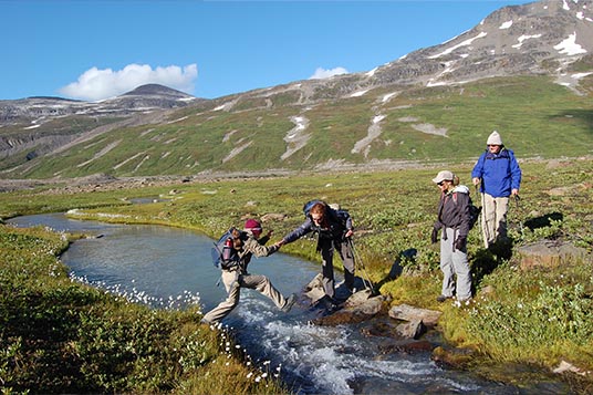 Hikers cross a stream in the Alaskan backcountry