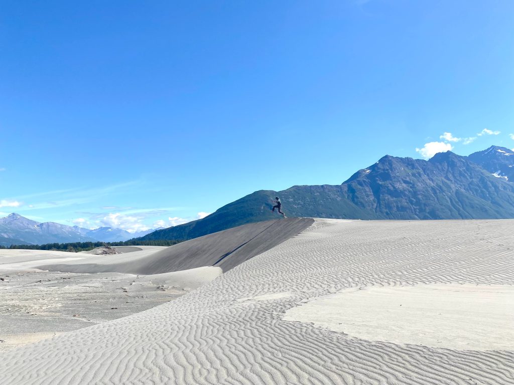 backcountry guide jumps off Bremner sand dune on the copper river in the backcountry