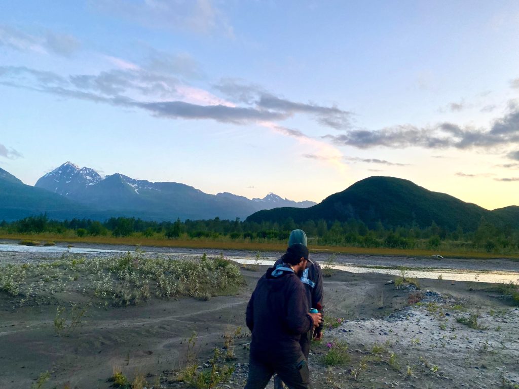 Two wilderness guides walk along river bank