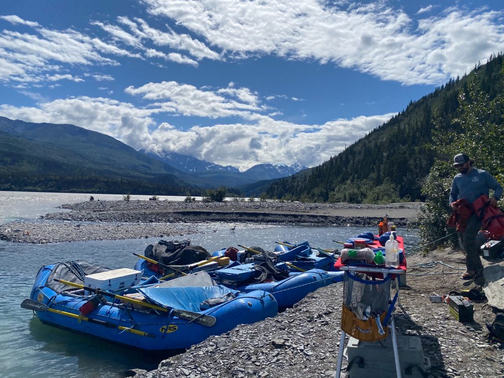 Rafts being inflated in Chitina, raft guide sets up tables for lunch
